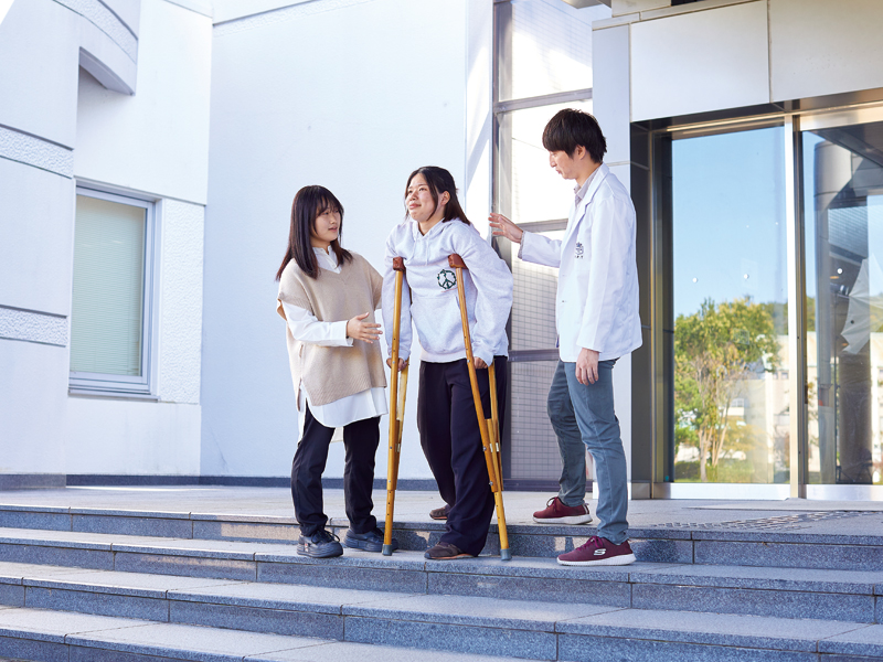 松葉杖をつく患者役の学生